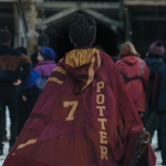 Harry Potter corre hacia el campo de Quidditch con túnica y escoba en mano, listo para su primer partido en Hogwarts.