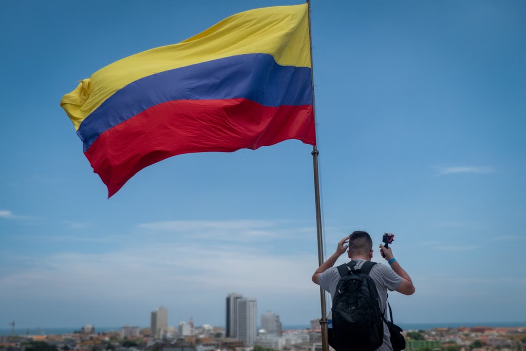 hombre junto a la Bandera de Colombia